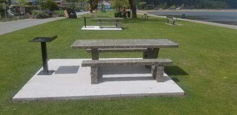 Picnic tables on a grassy area at the edge of the lake